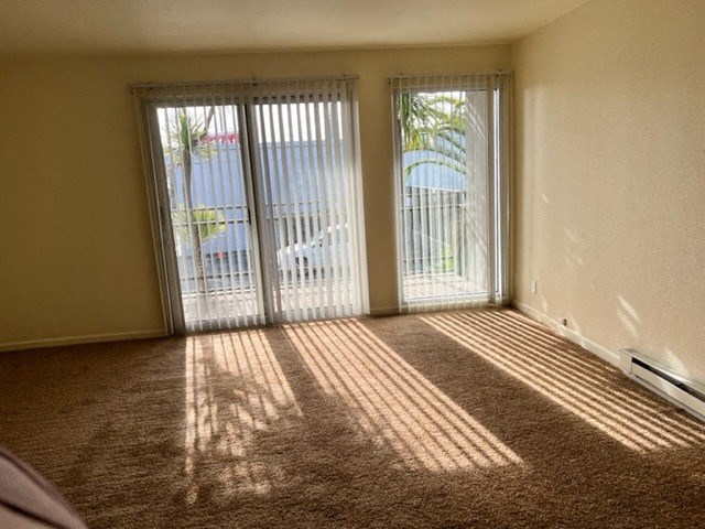 an empty living room with doors to a balcony
