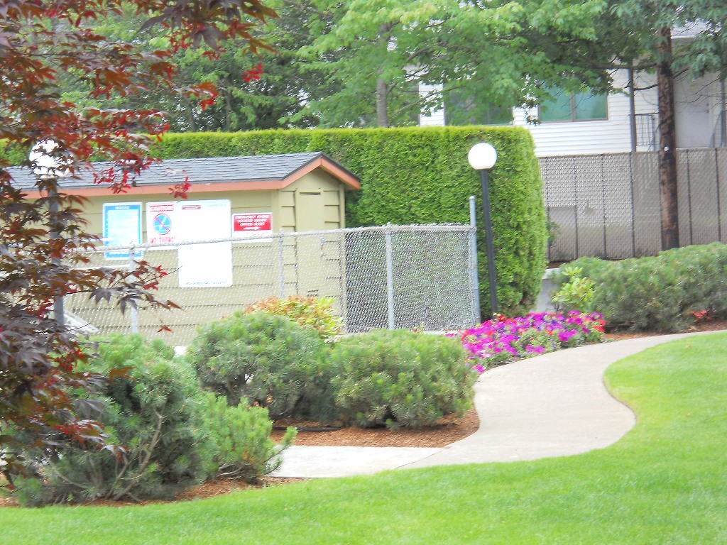 a walkway through a garden in front of a building