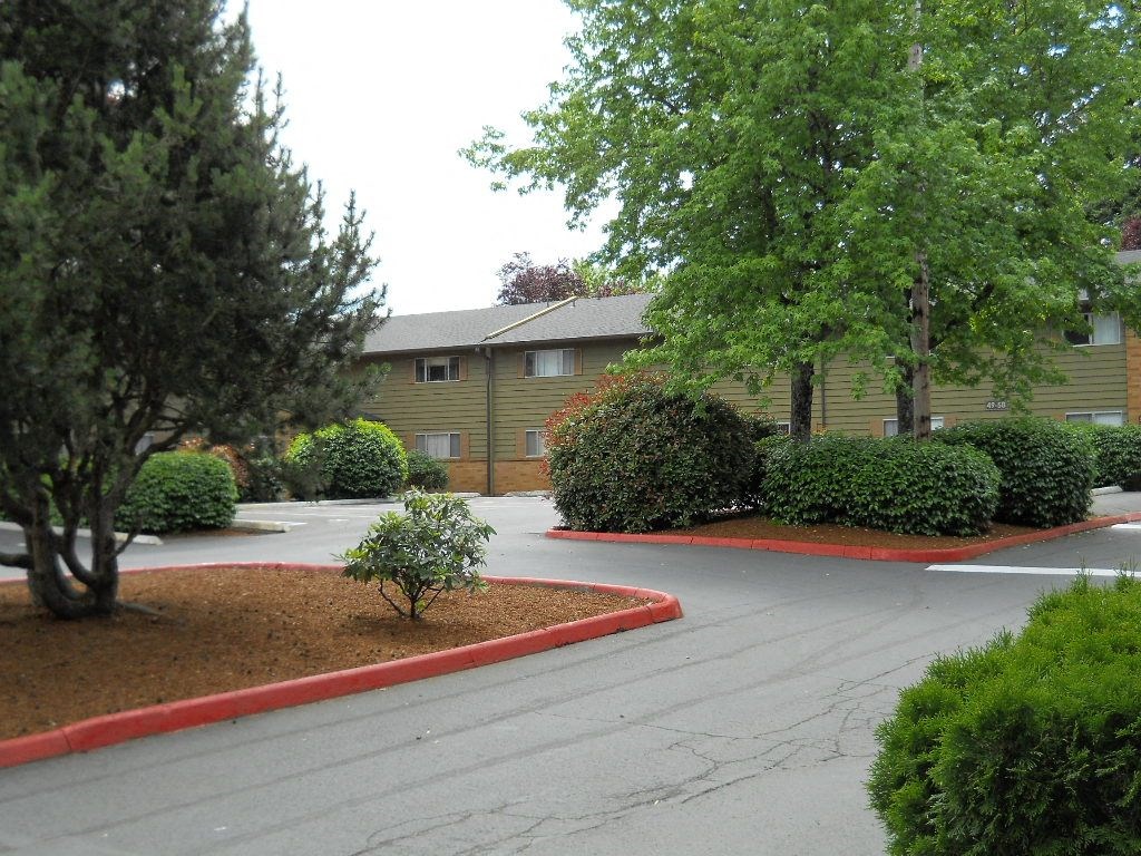 an empty parking lot in front of an apartment building