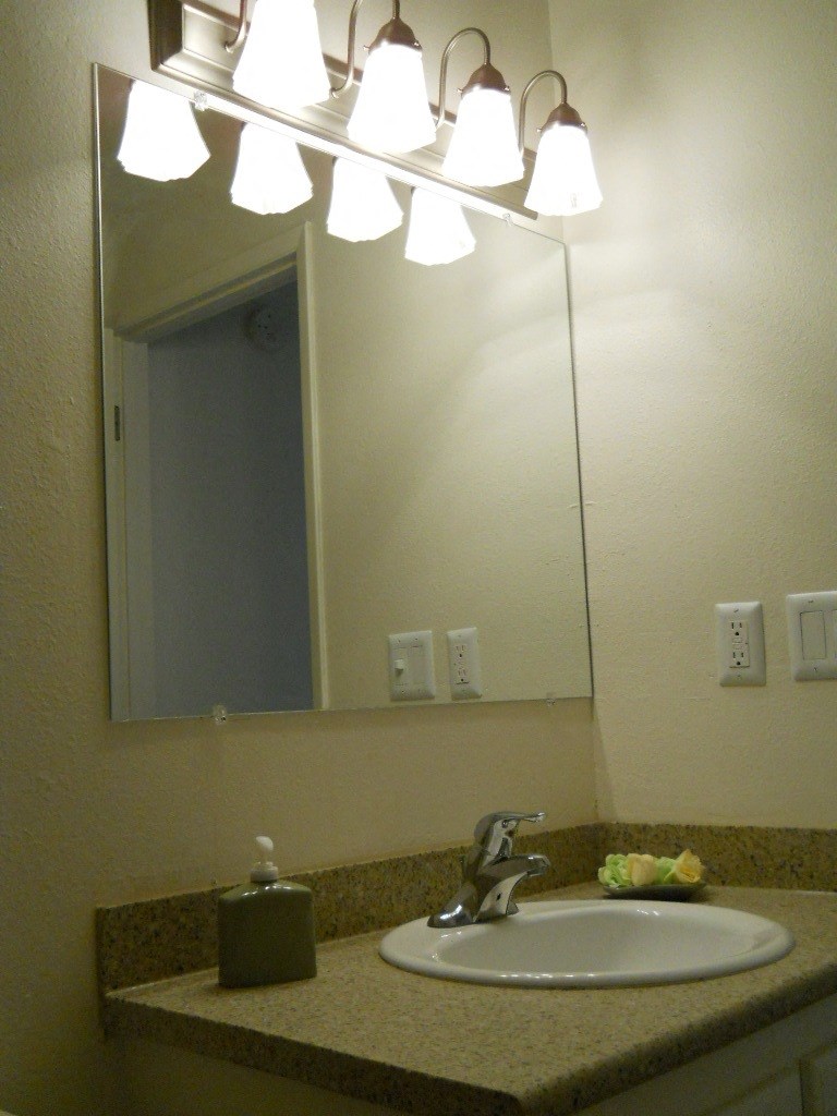a bathroom sink with a mirror and lights above it