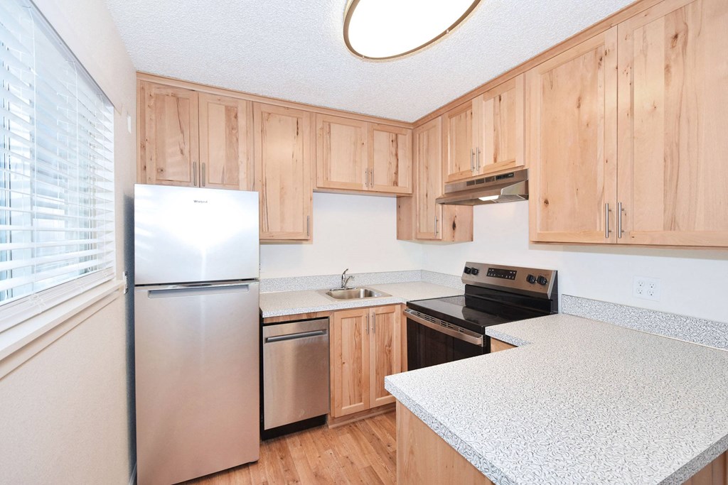 a kitchen with white counter tops and wooden cabinets