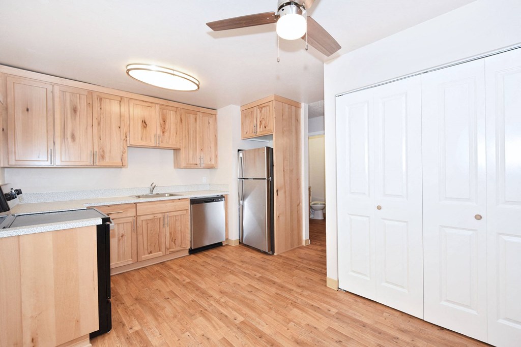 an empty kitchen with wood flooring and wooden cabinets
