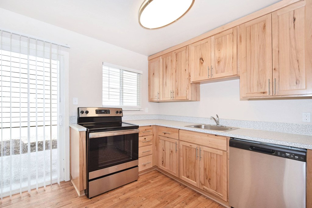 a kitchen with wooden cabinets and stainless steel appliances
