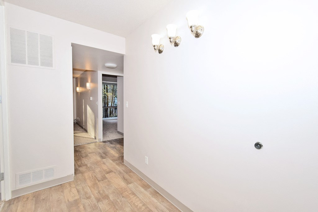 a renovated living room with white walls and wood floors
