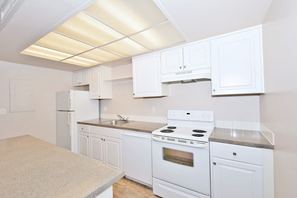a kitchen with white appliances and counters and white cabinets