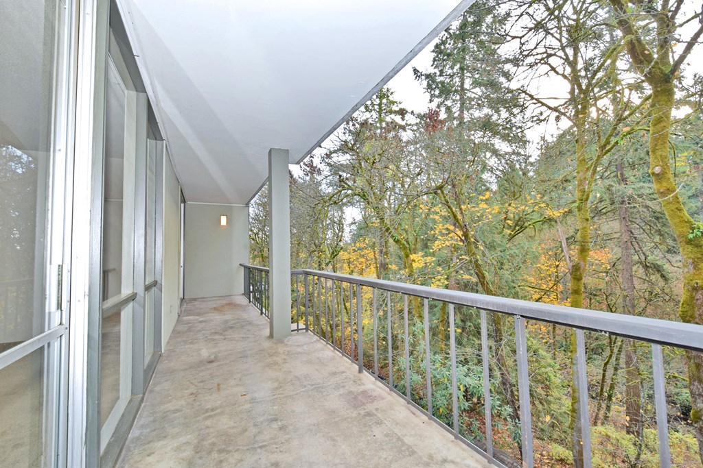 a view of the forest from a balcony of a house