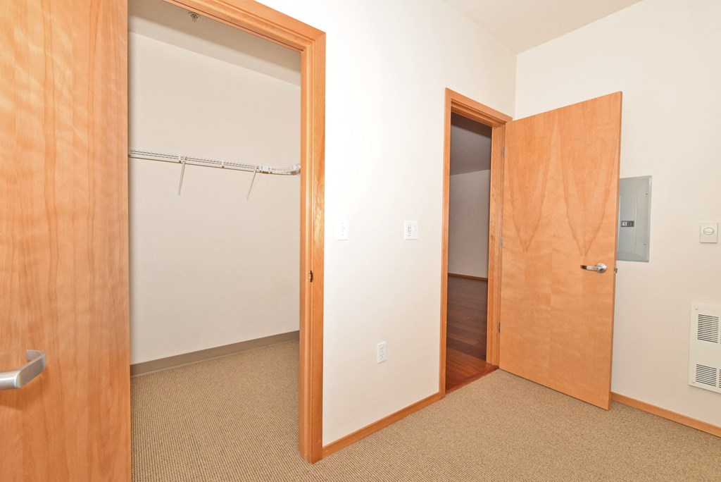 a bedroom with a closet and a door to a hallway