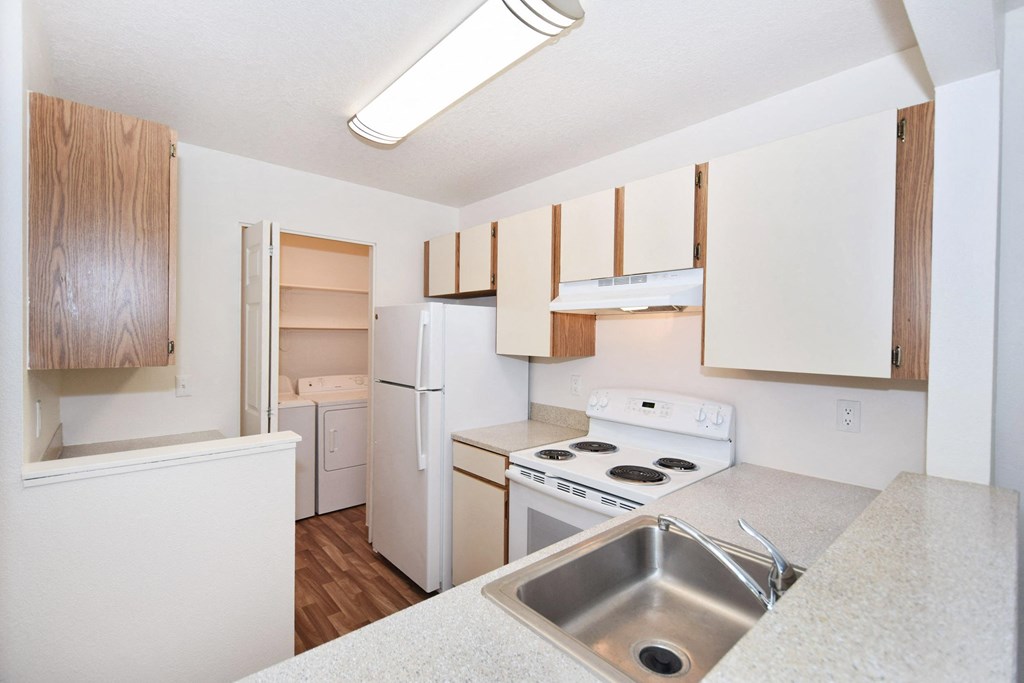 a kitchen with white appliances and wooden cabinets