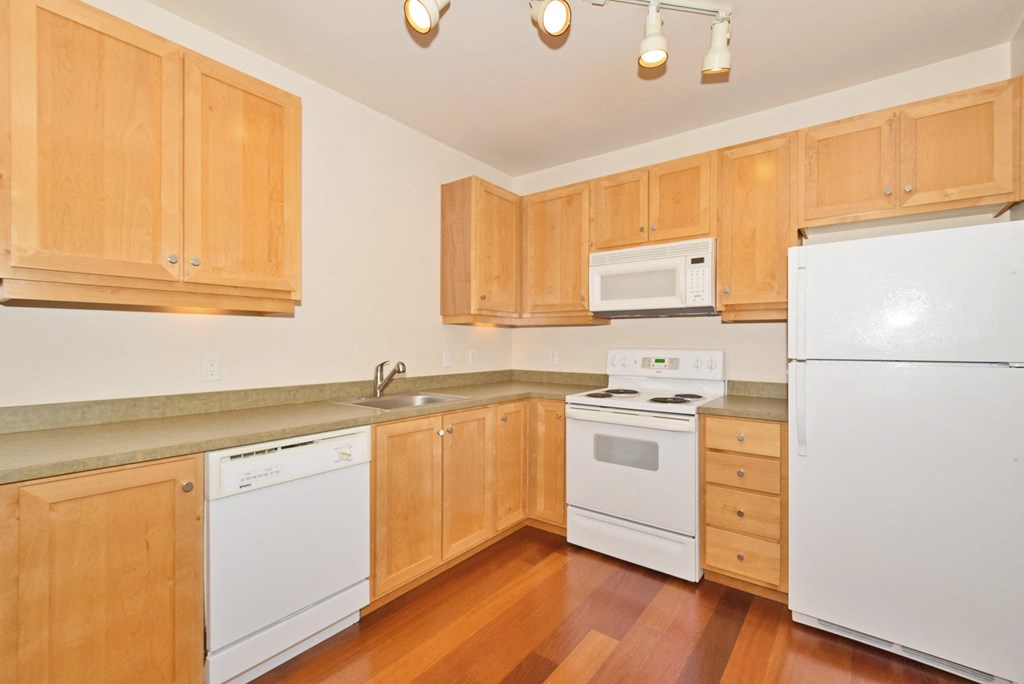 a kitchen with white appliances and wooden cabinets
