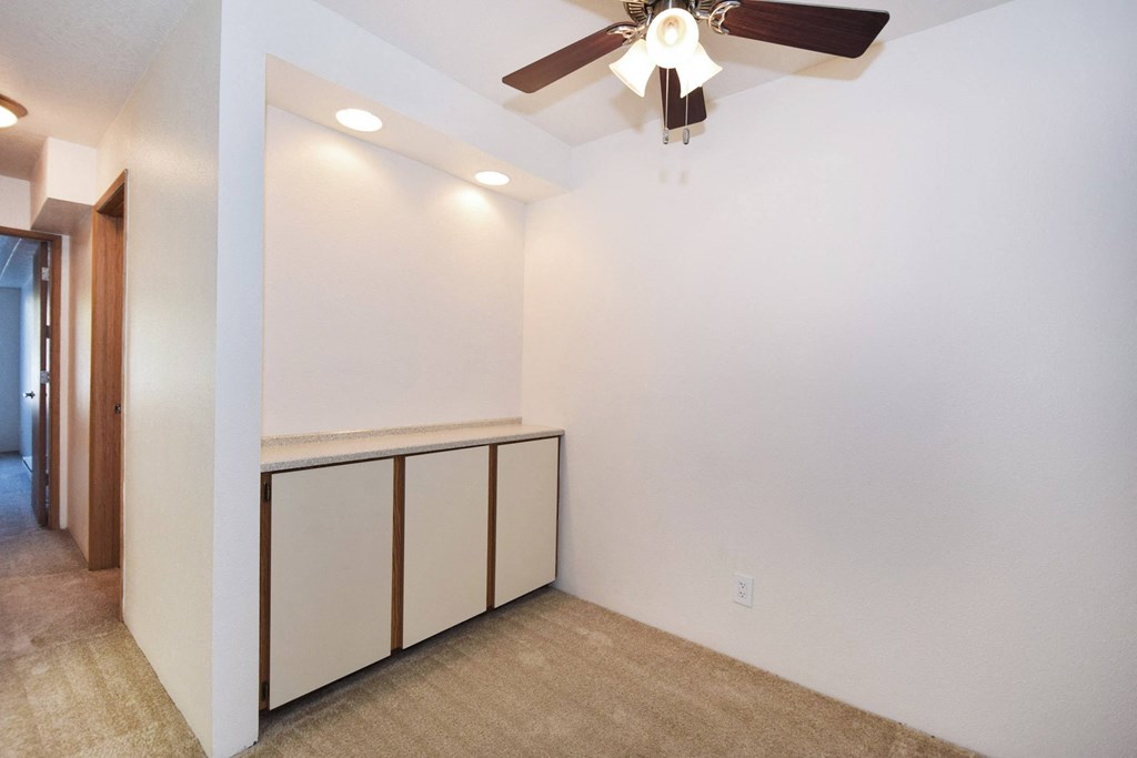 a room with white walls and a ceiling fan