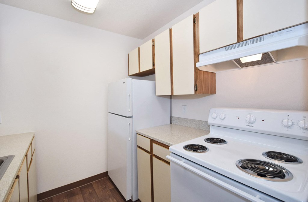 a kitchen with white appliances and wooden cabinets and a white stove