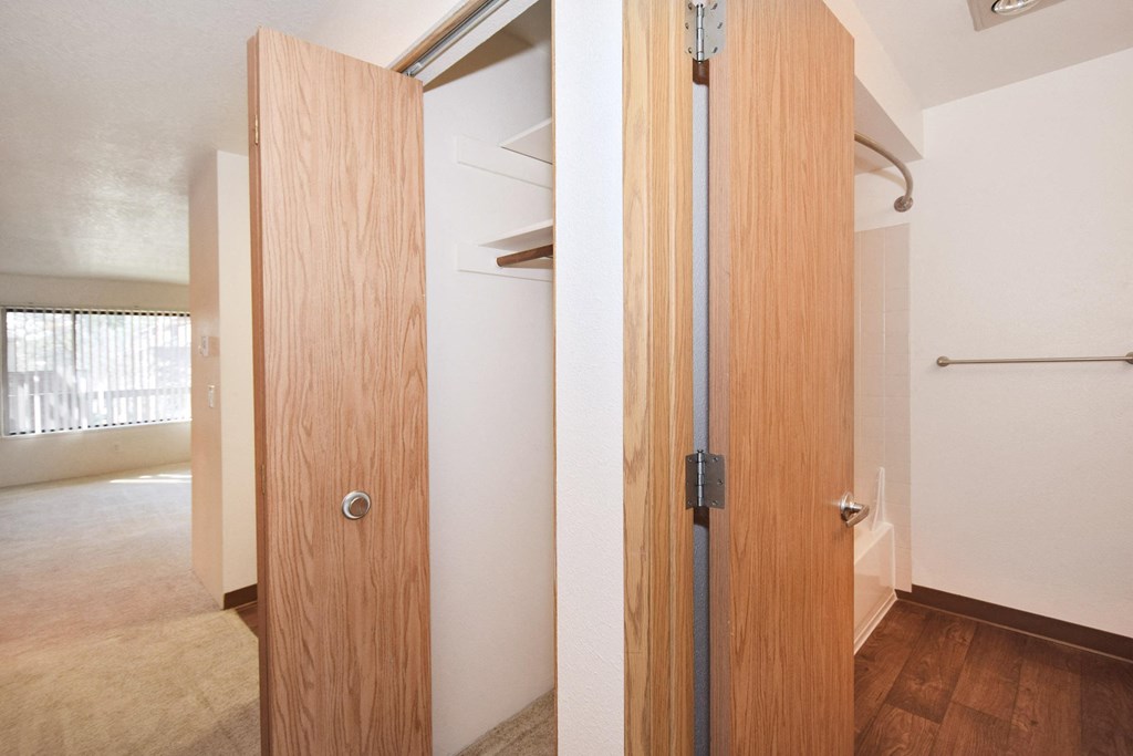 a door to a bathroom and a hallway with a closet