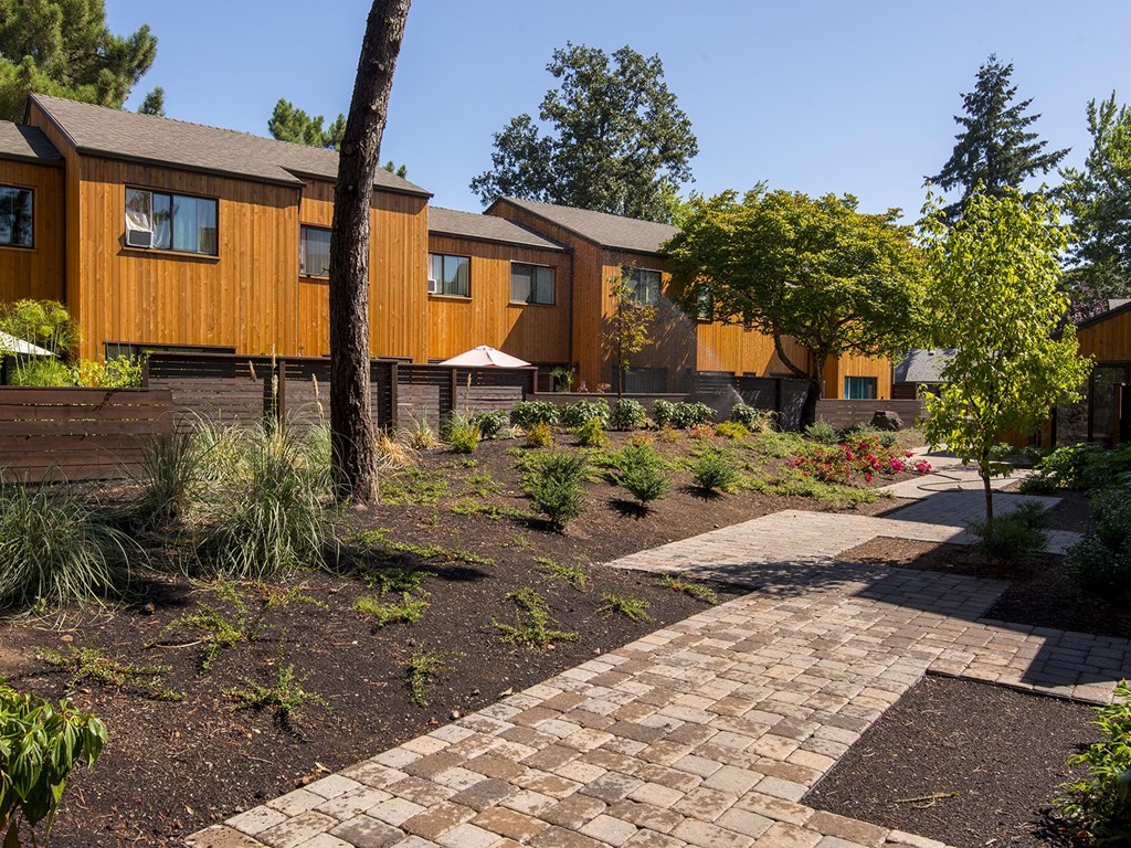 a courtyard with a path and houses in the background