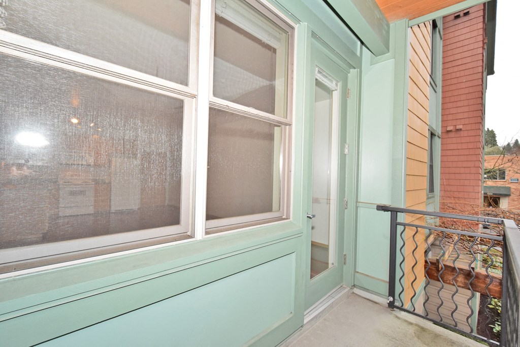 a balcony with a large window and a door to a house