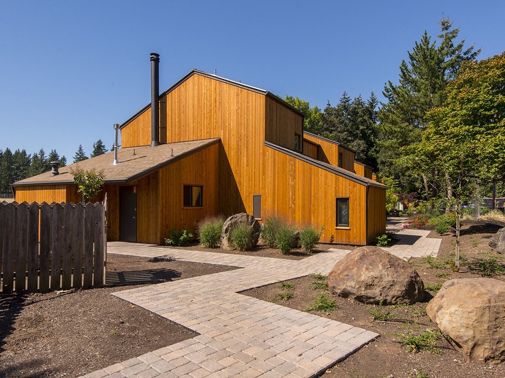 a wooden house with a courtyard and trees