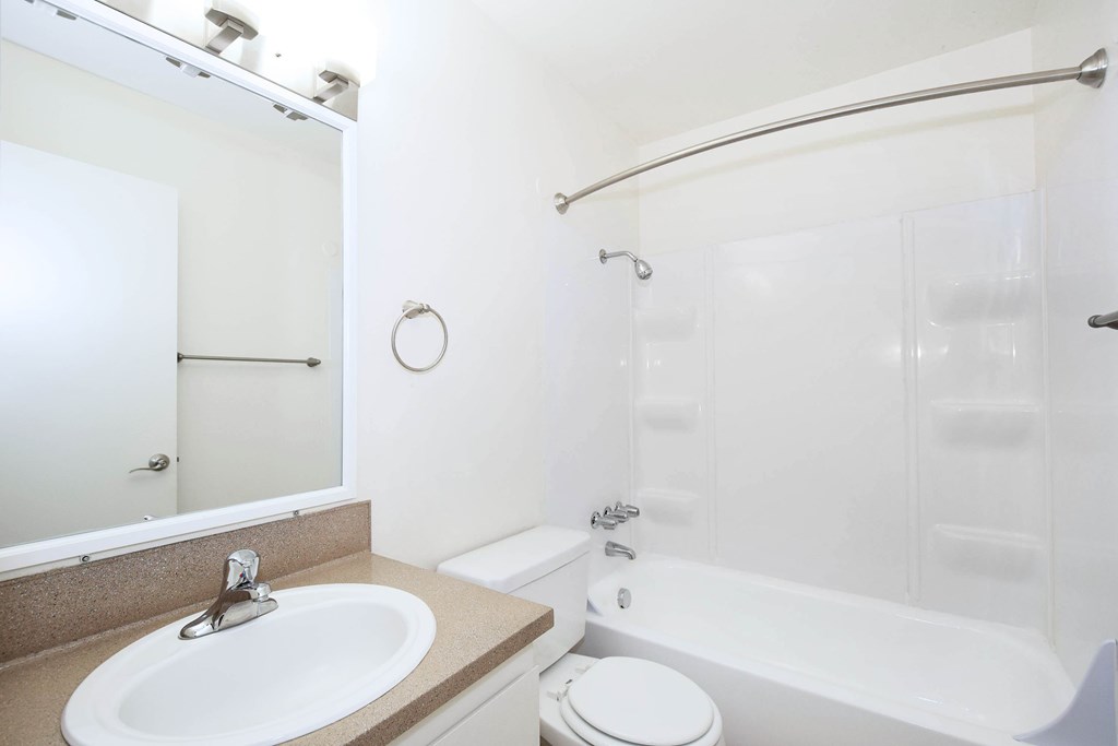A white bathroom with a sink, toilet, and bathtub.