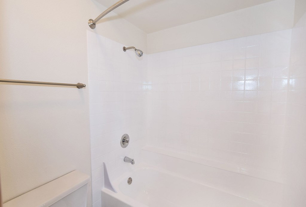 a white bathroom with a shower and a tub