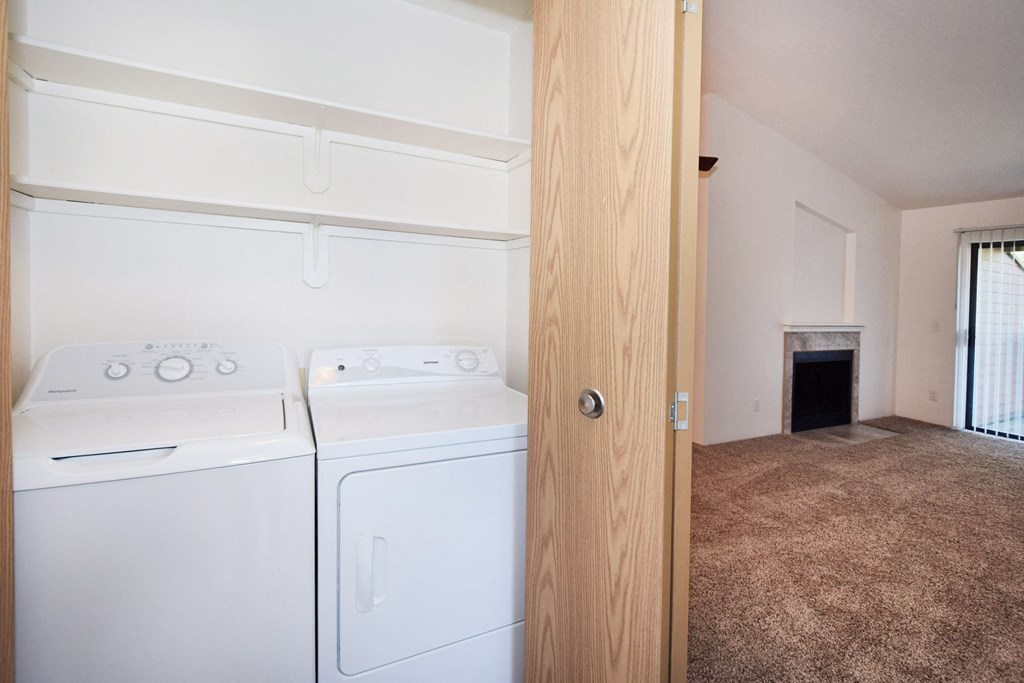 an empty laundry room with two washes and a dryer