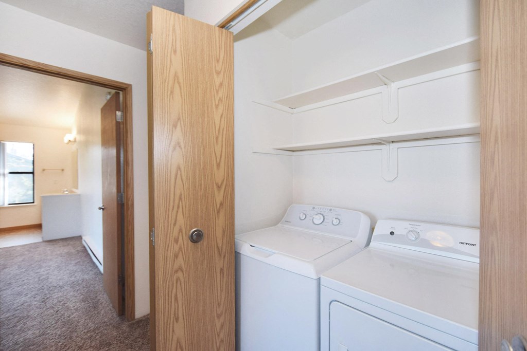 an empty laundry room with a washer and dryer in it