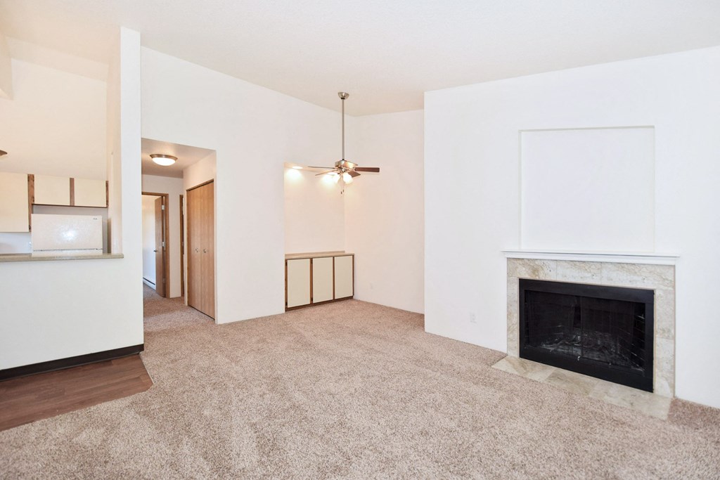 a living room with a fireplace and a carpeted floor