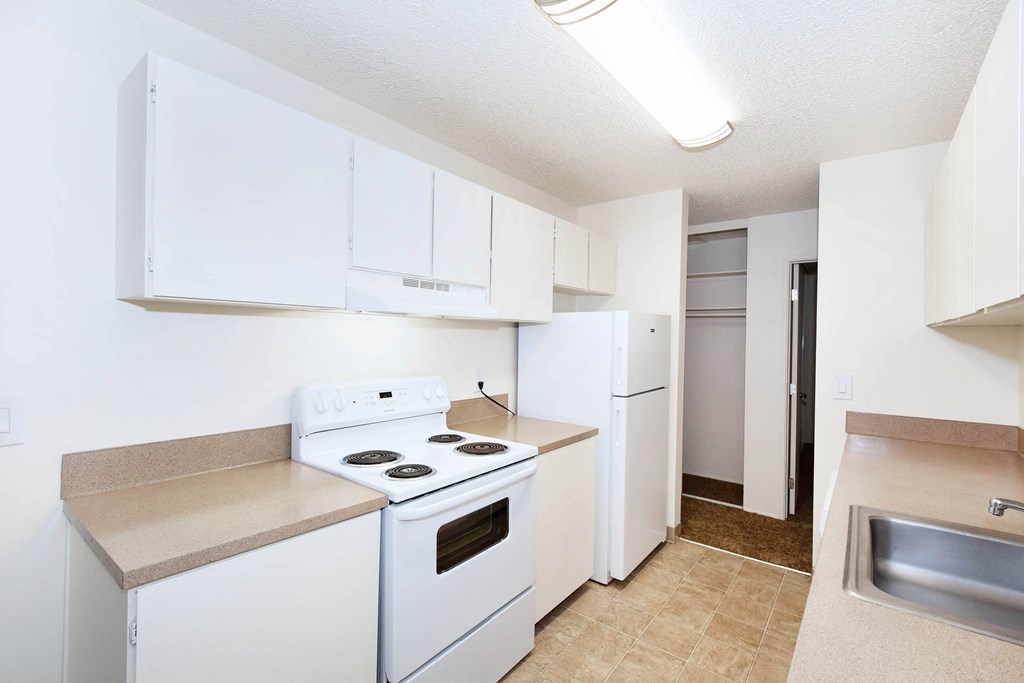 A kitchen with white appliances and cabinets.