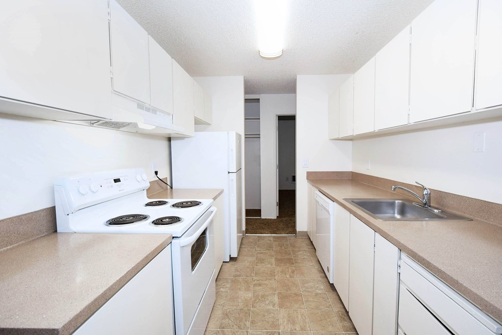 A kitchen with white appliances and cabinets.
