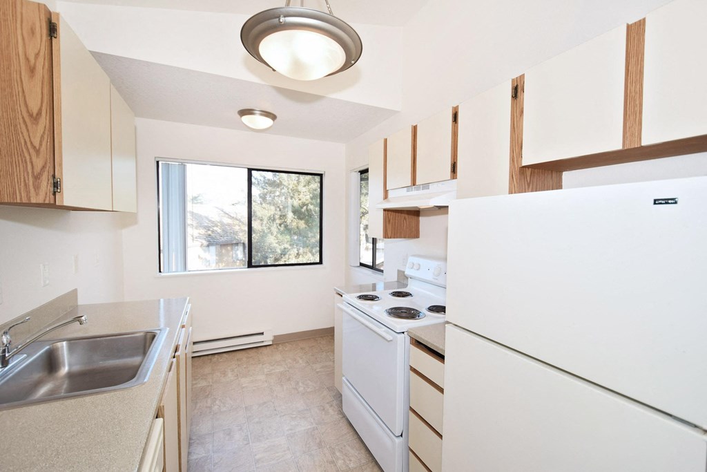 a kitchen with white appliances and a window