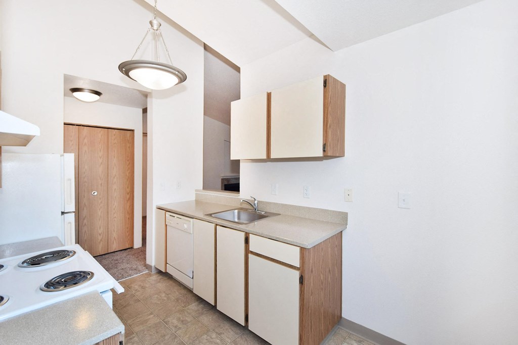 a kitchen with white cabinets and a stove and a sink
