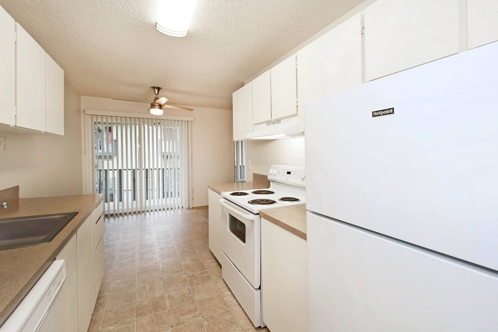 A kitchen with white appliances and cabinets.