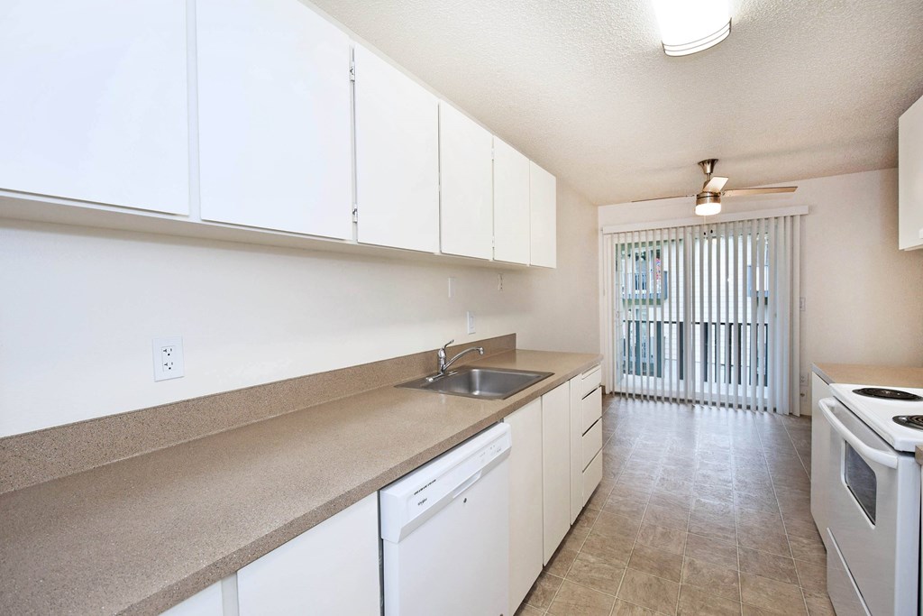 A kitchen with white cabinets and a counter top.