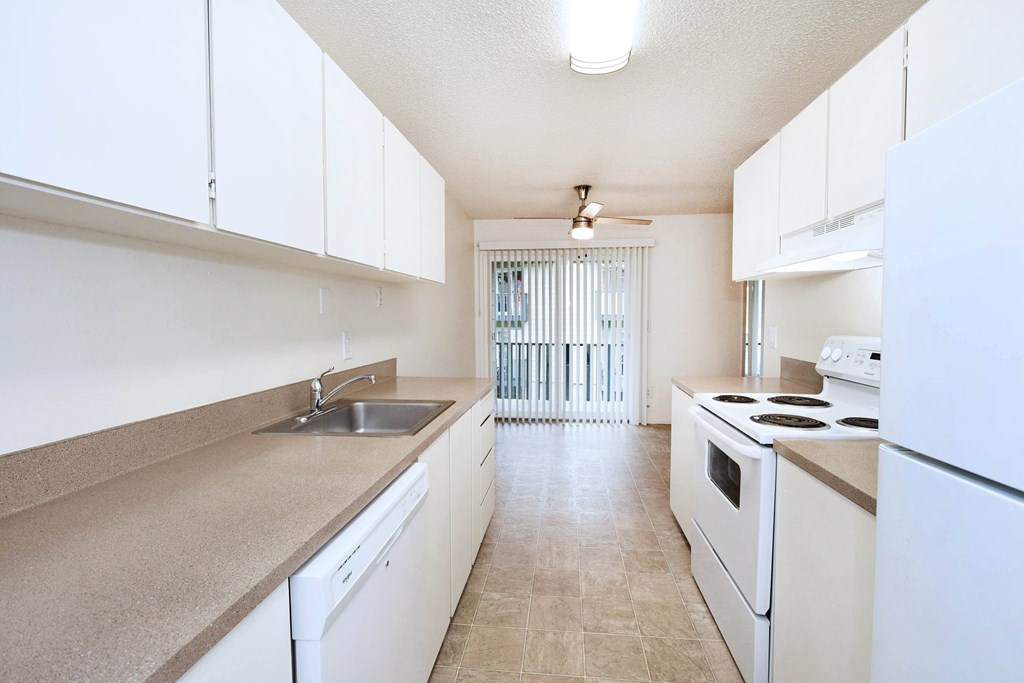 A kitchen with white appliances and cabinets.