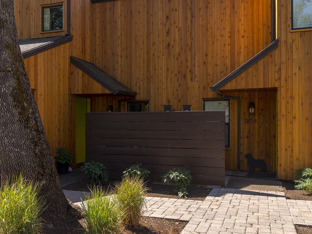 a brown privacy fence in front of a wooden house