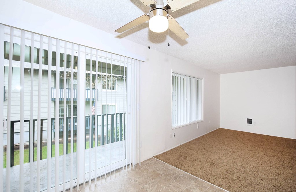 A room with a ceiling fan and a carpeted floor.