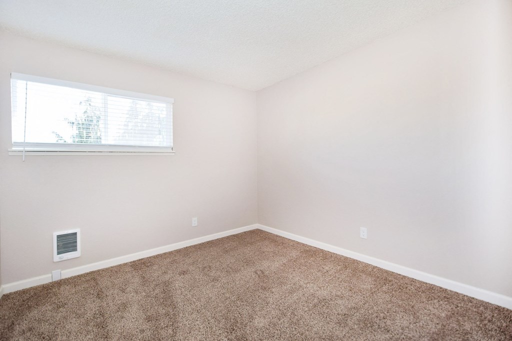 an empty room with carpet and a window