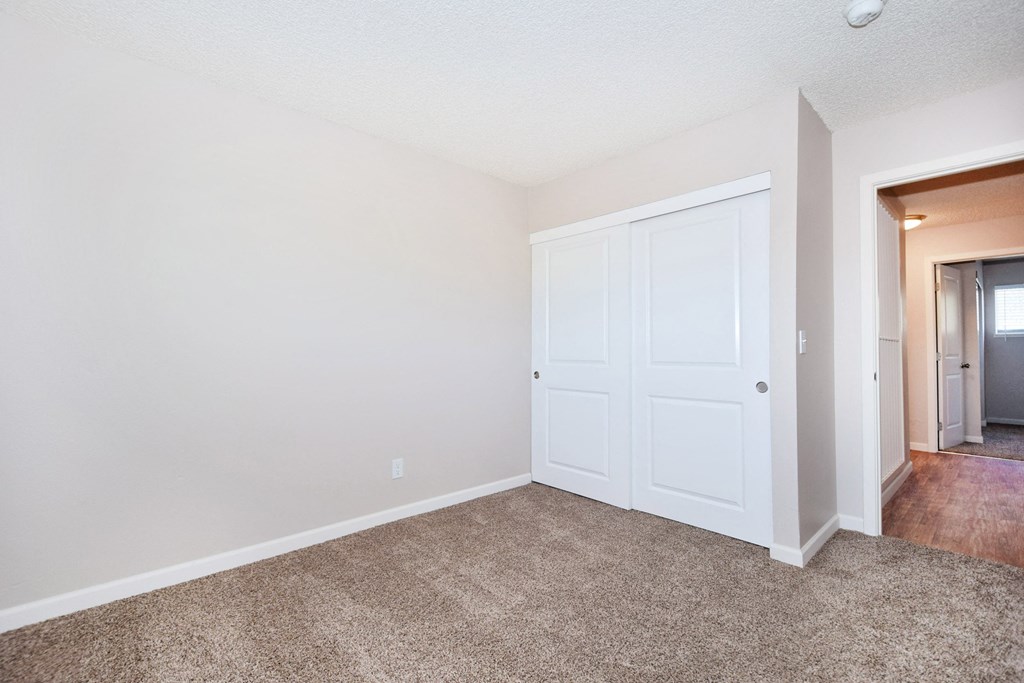 an empty living room with a door to a hallway