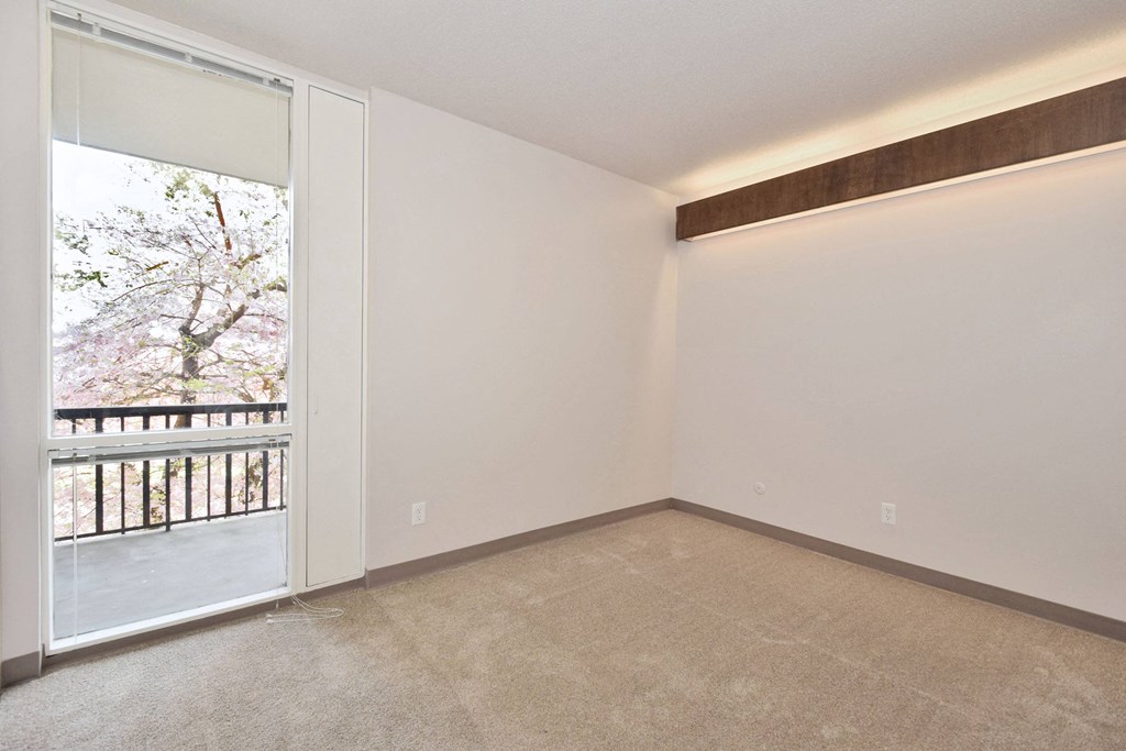 a living room with a large window and a door to a balcony