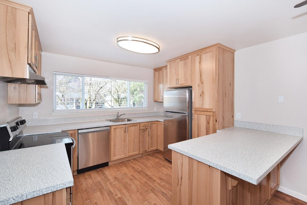 a kitchen with wooden cabinets and a white counter top