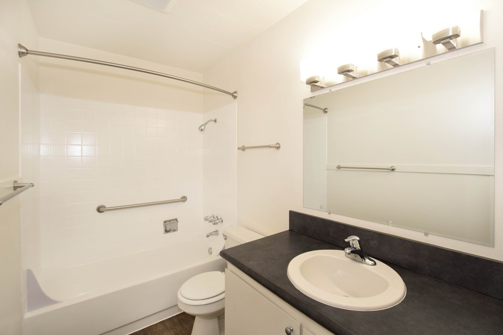 A bathroom with a toilet, sink, and shower.