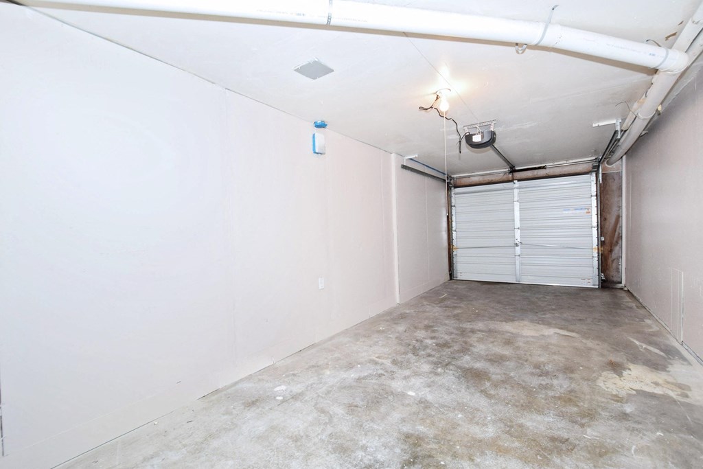 the interior of a garage with white walls and a garage door