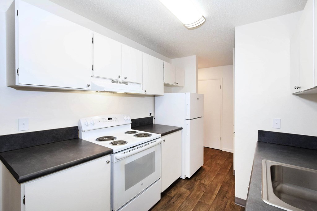 A kitchen with white appliances and cabinets.