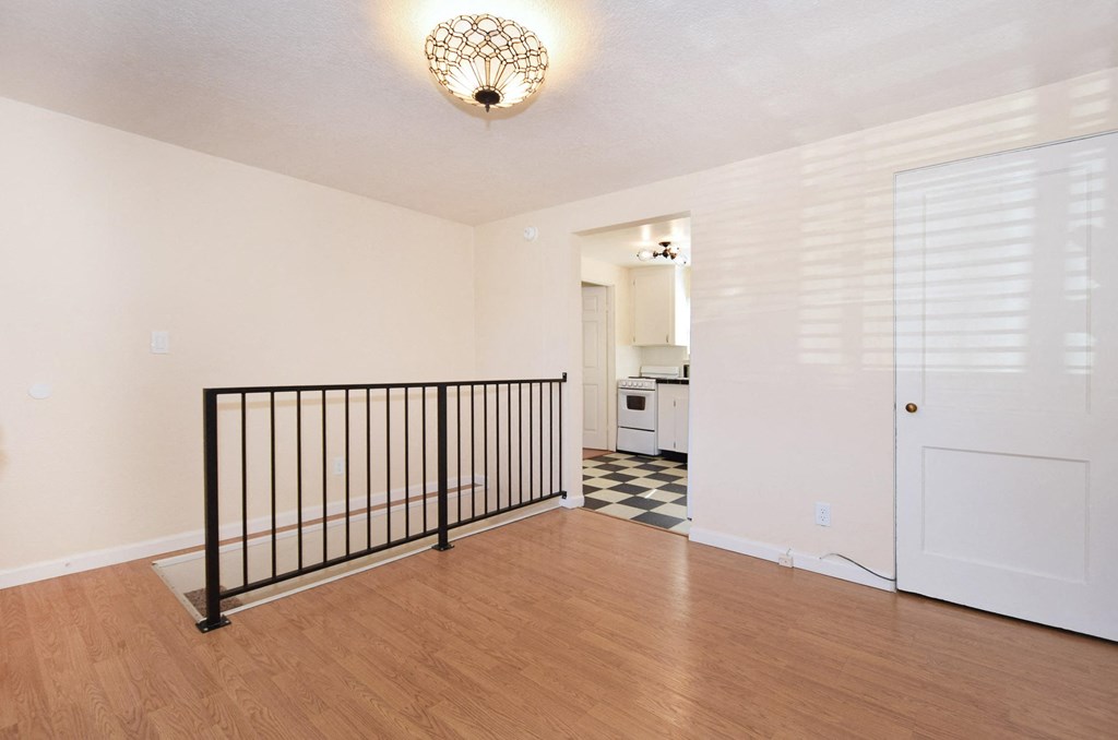 a living room with a staircase and a door to a kitchen