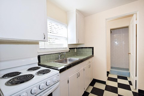 a kitchen with a stove sink and white cabinets