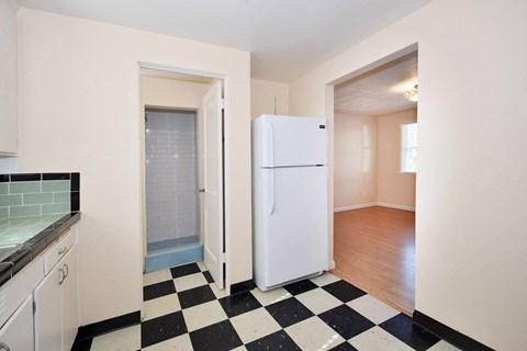 a kitchen with a checkered floor and a white refrigerator