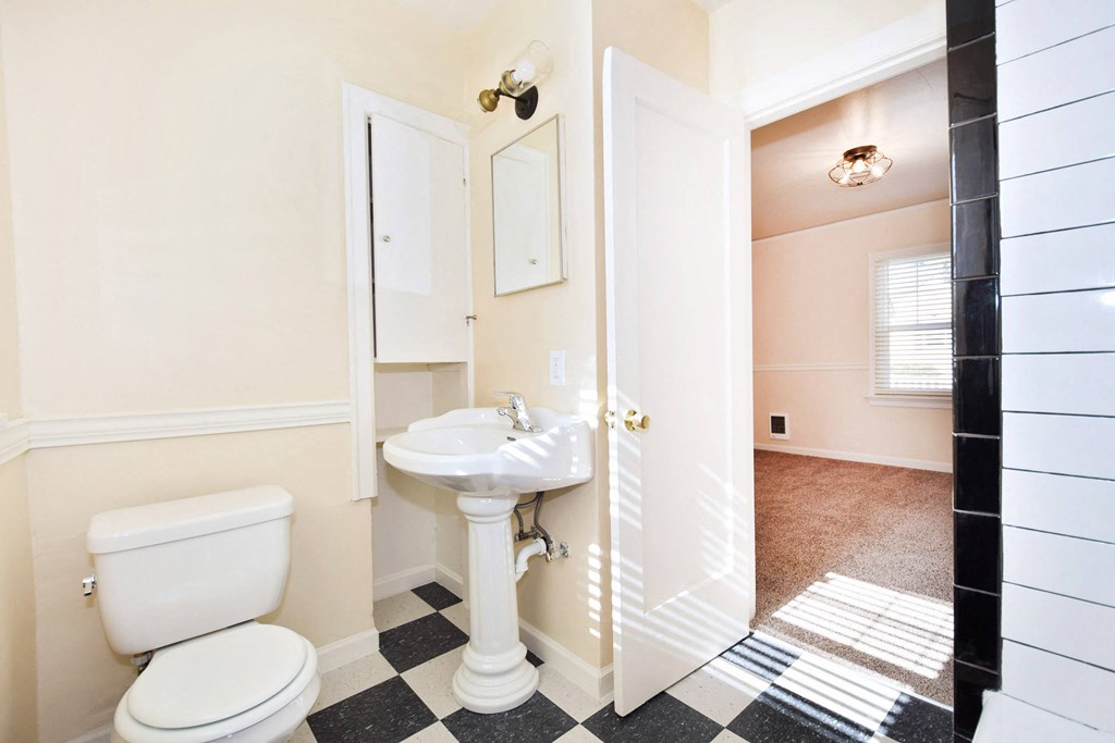 a bathroom with a sink toilet and a mirror