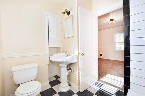 a bathroom with a sink toilet and a mirror
