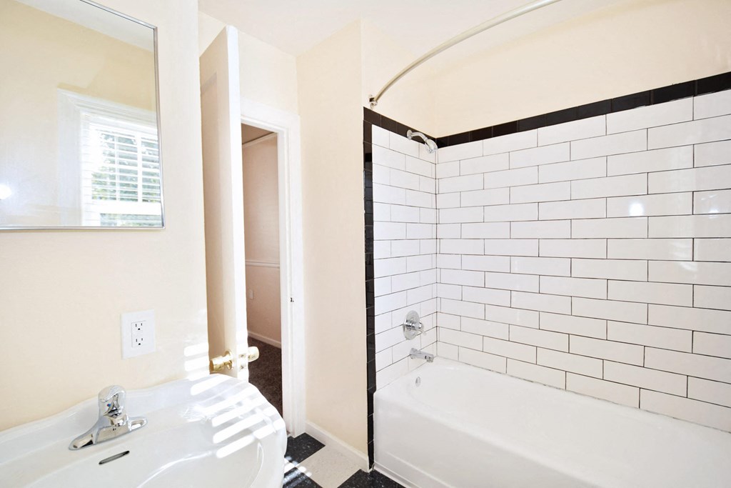 a bathroom with a tub and a sink and a mirror