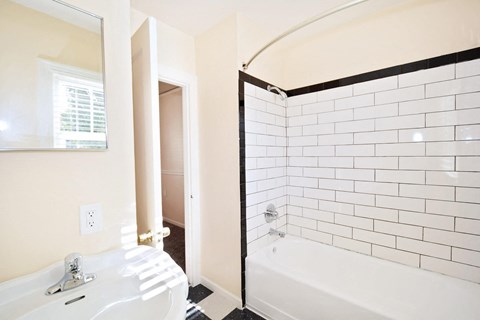 a bathroom with a tub and a sink and a mirror