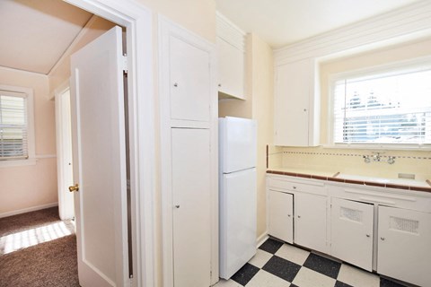a kitchen with a checkered floor and a white refrigerator