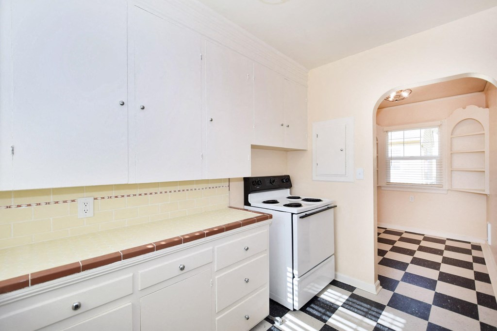 a kitchen with a checkered floor and white appliances