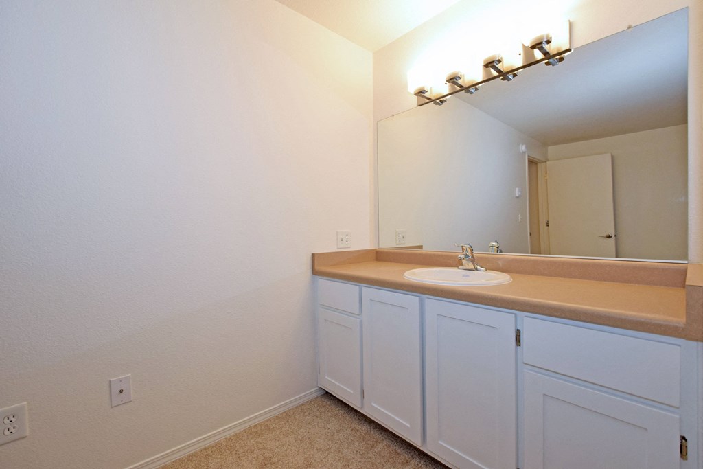 an empty bathroom with a sink and a mirror